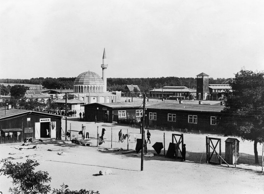 Historische Aufnahme der hölzernen Moschee im Halbmondlager Wünsdorf aus dem Jahr 1917, dahinter die Baracken des Lagers